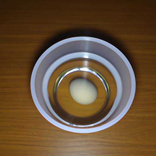 Float the egg in a bowl of cold water and observe whether it sinks or floats